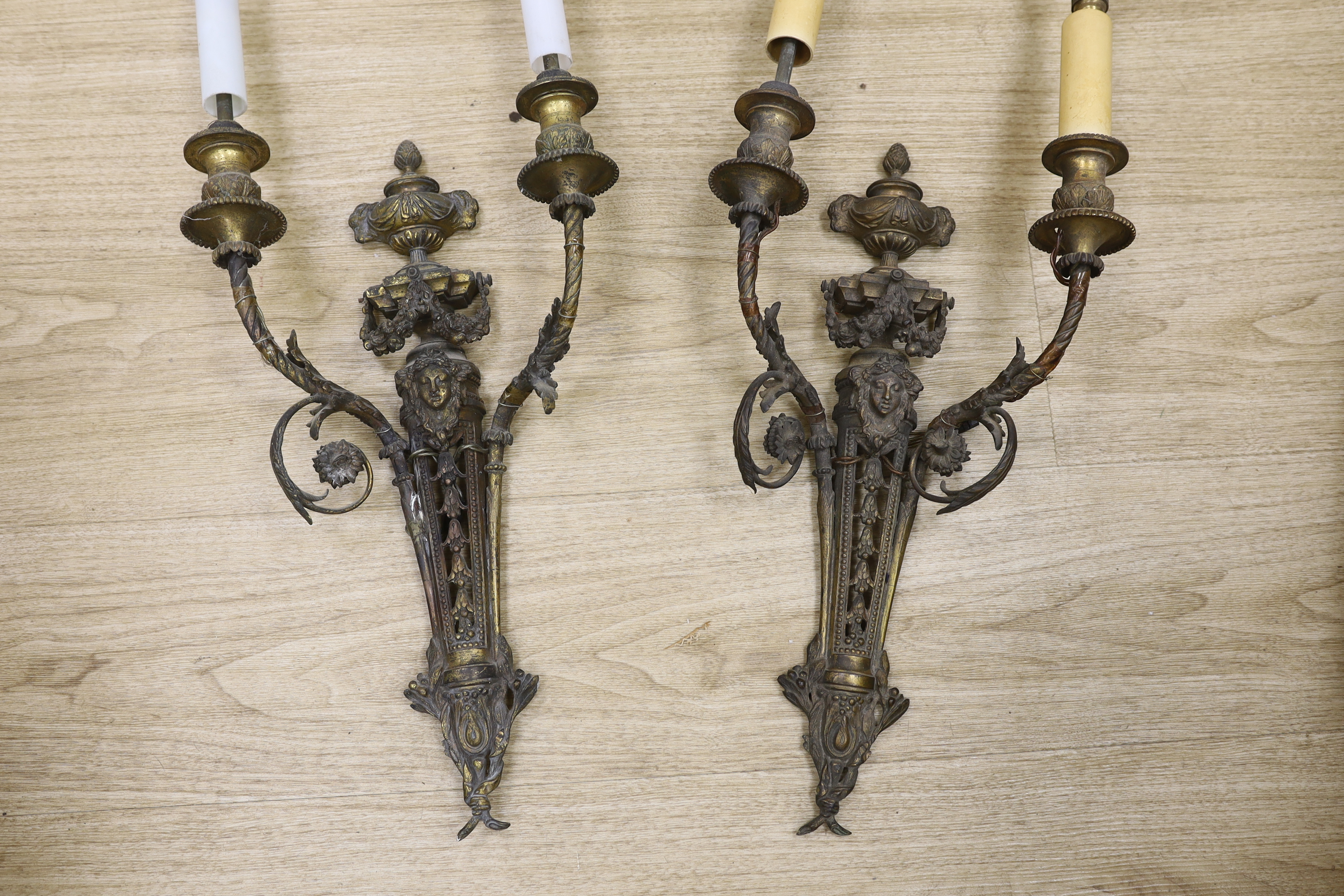 A pair of Louis XVI style cast brass two branch wall lights, 60cm high including fittings. Condition- fair to good, grubby, in need of rewiring